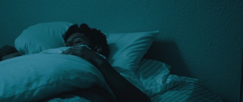 Man sleeping peacefully at night, showing the importance of recovery in post-weightlifting routines