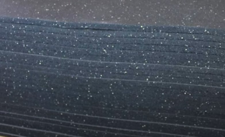 A stack of black foam sheets featuring white speckles throughout the surface
