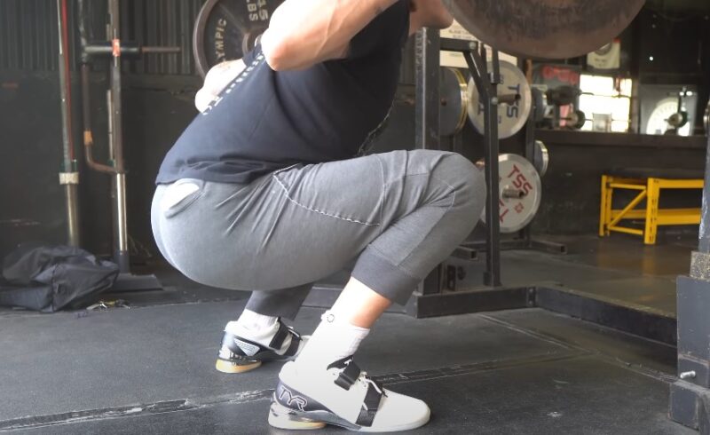 Guy lifting weights wearing white Olympic weightlifting shoes