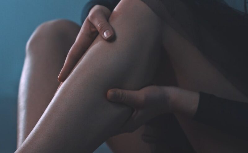Woman holds her calf muscle after an injury