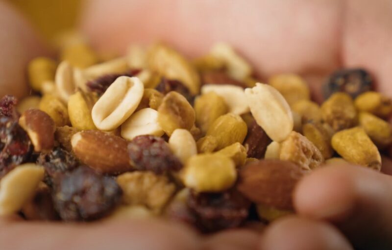 Close up view of dried fruits and nuts in a human hand