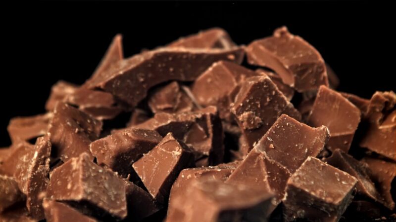Pile of chopped dark chocolate pieces against a black background