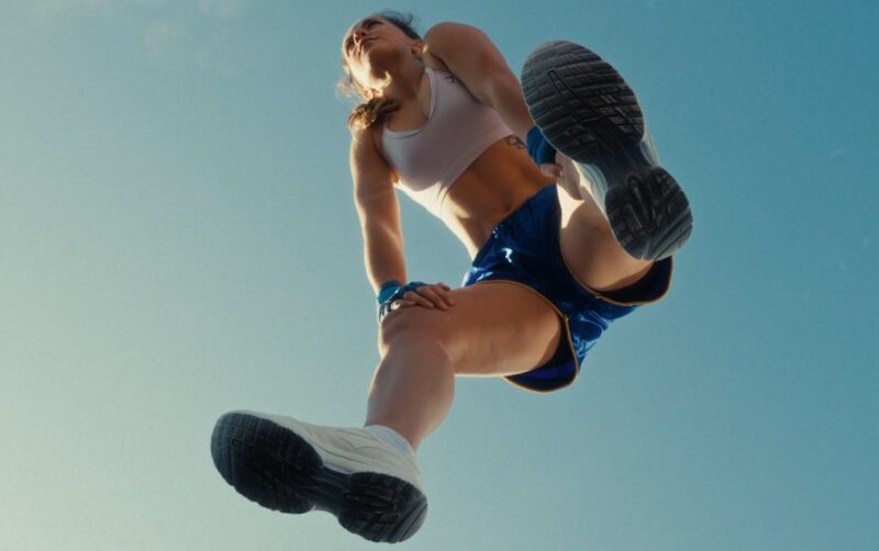 A woman in a sports bra and shorts resting after running