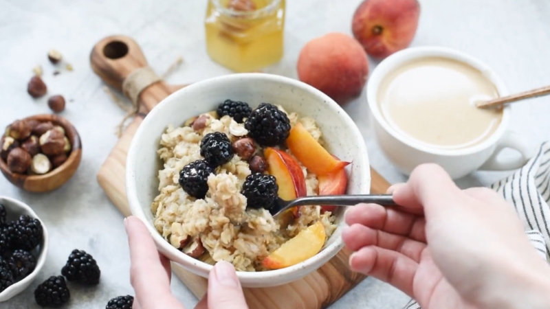 A bowl of oats with fruit and nuts shown alongside common foods linked to higher inflammation