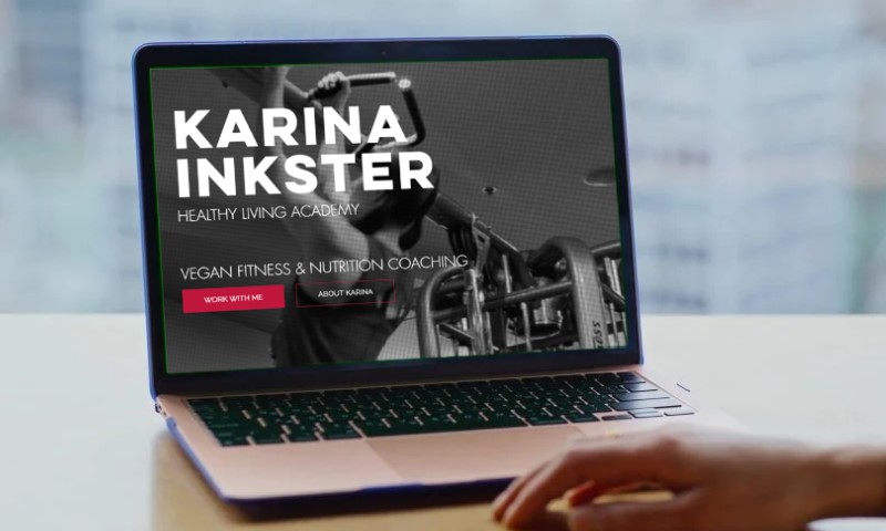 A laptop screen displays a fitness and nutrition coaching website