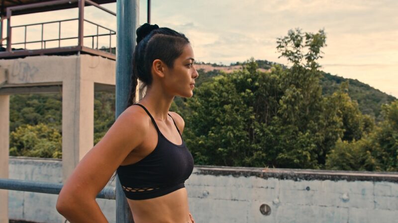 Person standing outdoors in athletic wear, pausing between training activities